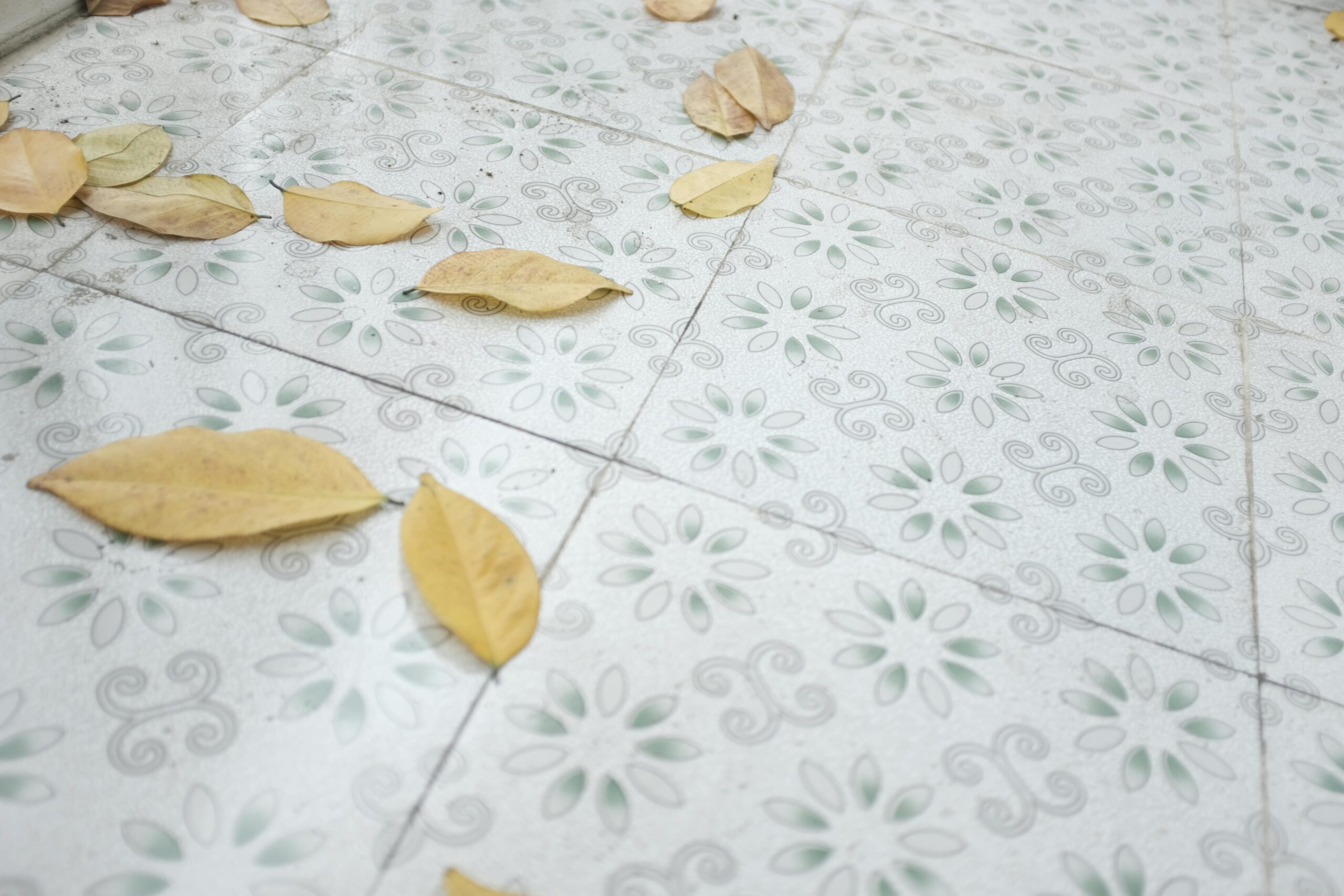 Decorative tiles adorned with autumn leaves scattered across the floor.